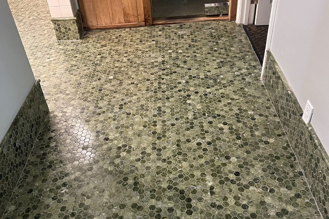 Polished marble floor after restoration of a shower in Los Angeles, highlighting the smooth finish of green marble mosaic tiles.