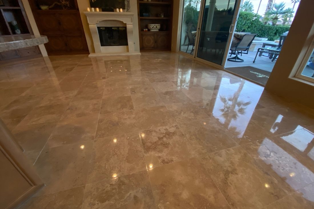 Polished travertine floor in a living area, showcasing a glossy finish after StoneShine's restoration that includes cleaning, polishing, and sealing in Huntington Beach.